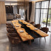 Modern dining room with a long wooden table and chairs in a stylish interior.