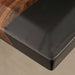 Black rectangular object with wooden edge on a neutral background