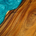 Close-up of a wooden surface with a blue resin filling a crack.