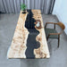Wooden dining table with black resin inlay in a modern interior setting