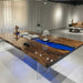 A custom resin river table with transparent acrylic base creating a unique floating illusion in a minimalist interior.