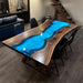 Custom live edge walnut wood desk with glowing blue resin center and sleek metal legs