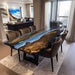 Golden camphor dining table with ocean-blue epoxy and live-edge design.