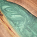 Custom handmade walnut table with flowing green resin river