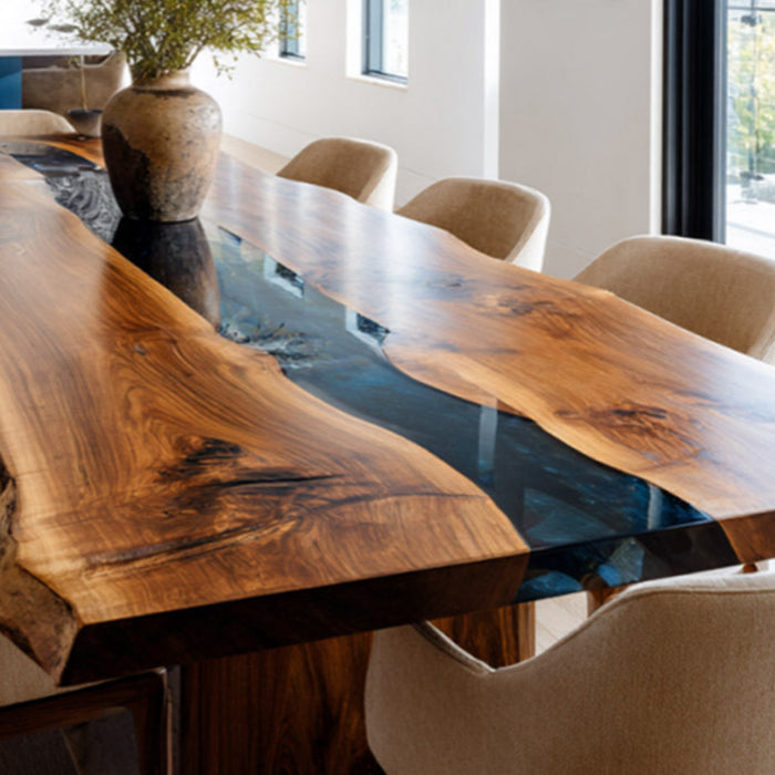 Dining table with wooden surface and blue glass inlay, surrounded by chairs in a modern interior setting.