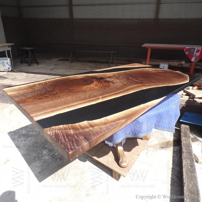 Handcrafted black walnut dining table with modern black epoxy resin river design.