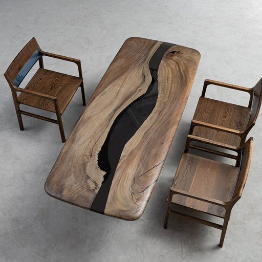 Modern walnut live edge dining table with a striking black resin river inlay, showcasing organic wood grains and natural imperfections for elegant contemporary interiors.