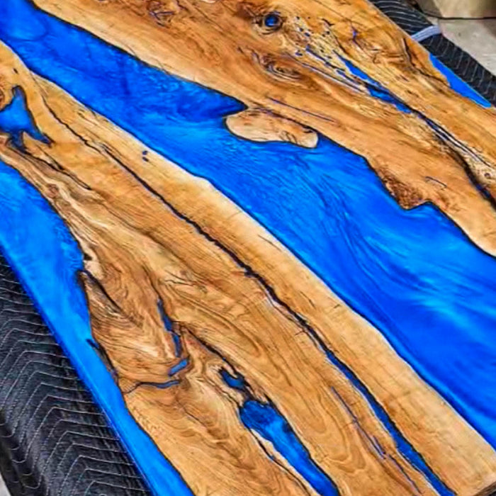 Handcrafted epoxy river table with live edge olive wood and ocean blue resin