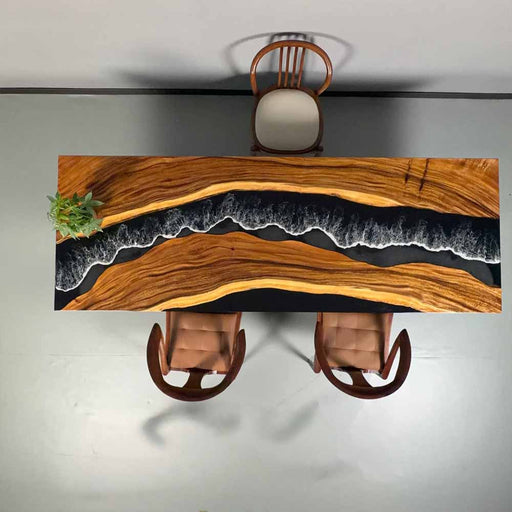 Wooden desk with a live edge design, black resin inlay, and two chairs.