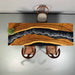 Wooden desk with a live edge design, black resin inlay, and two chairs.