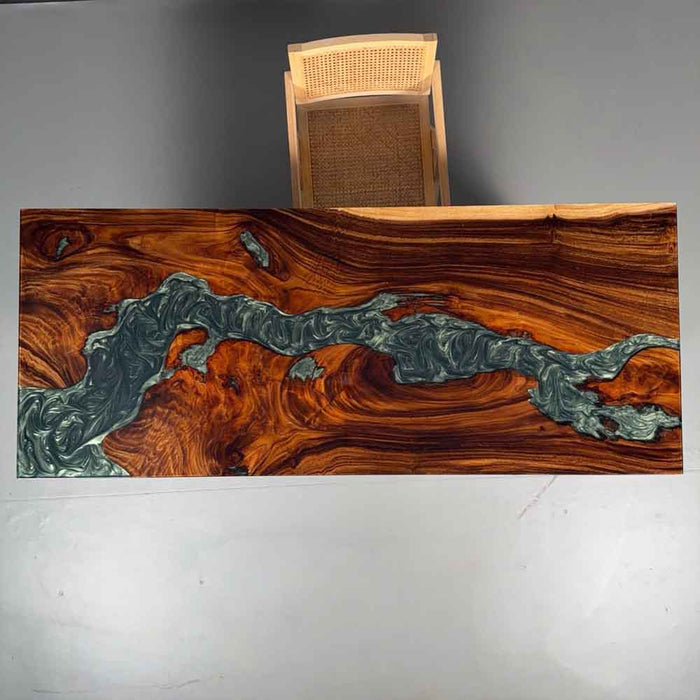 Wooden table with a unique grain pattern and embedded green material on a plain background