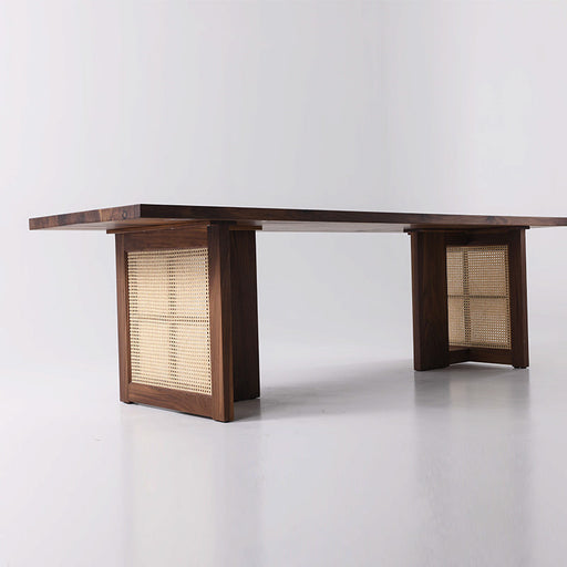 Handcrafted black walnut dining table featuring modern rattan details