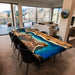 Modern living room with a unique wooden dining table featuring a blue resin design.
