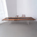 Wooden dining table with black resin inlay in a minimalistic room.
