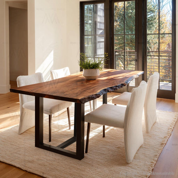 Dining room with a wooden table and white chairs near large windows.