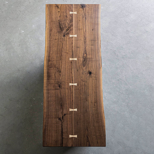 Handcrafted walnut wood table paired with Japanese-style chairs in a minimalist setting.