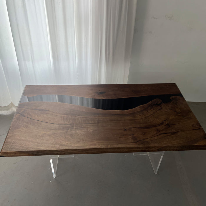 Black epoxy river dining table in a modern kitchen with mountain view.