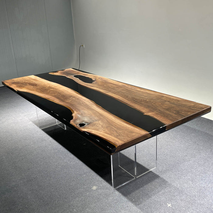 Wooden dining table with black resin inlay on a gray floor.