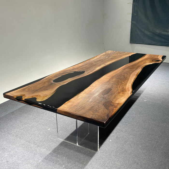 Wooden dining table with black resin inlay on a gray floor