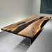 Wooden dining table with black resin inlay on a gray floor
