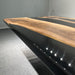 Modern black bathtub with wooden countertop in a minimalistic setting
