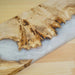 Wooden cutting board with a white resin finish on a wooden surface