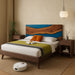 Bedroom with wooden bed, robot vacuum cleaner, and decorative items.