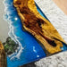 Wooden surface with blue resin and beach scene design on a textured surface