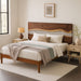 Wooden bed with bedding and side tables in a bedroom setting