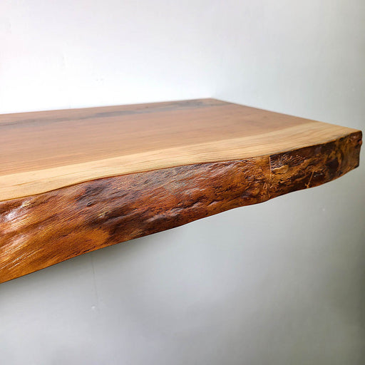 Wooden shelf with a natural edge design on a plain background