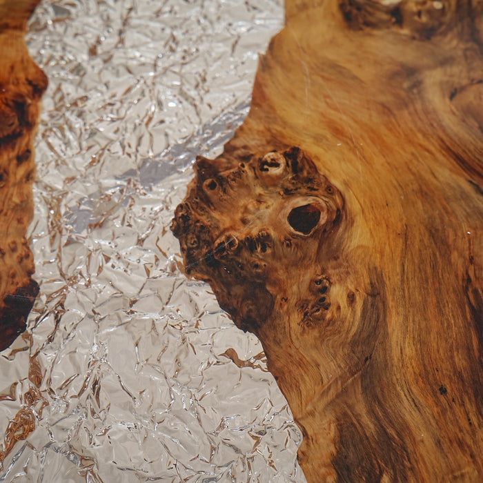Glass-like epoxy table with wood accents for contemporary interiors.