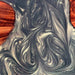 Close-up of a marbled pattern with swirling black and gray design on a red background
