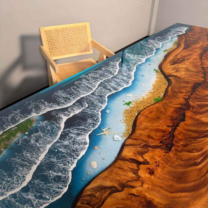 Table with a scenic design of a beach and desert, accompanied by a chair.