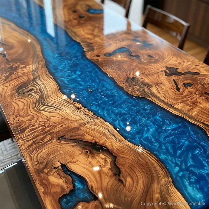 A close-up of a polished live-edge wooden table featuring dramatic swirling natural wood grain in warm brown and tan tones, divided by a vivid blue resin channel.
