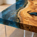 Made-to-order live edge epoxy resin dining table customized in size, resin color, edge style, and base options.