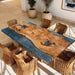 Close-up view of the live edge black walnut river table showing unique wood textures, organic edges, and deep blue epoxy resin details.