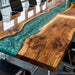 Glossy teal epoxy river flows through the walnut tabletop, creating a modern luxury statement piece.