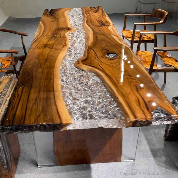 Custom black walnut dining table featuring a clear ice-effect epoxy river design and natural live edge wood grain.