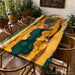 Custom golden camphor dining table featuring a flowing green epoxy river and natural wood grain patterns.