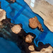 Custom blue epoxy river dining table crafted from natural poplar wood