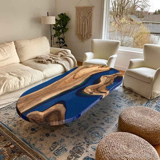 Boat shaped black walnut coffee table with blue epoxy river