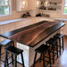 Black walnut epoxy island top with a black resin river in a modern kitchen