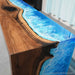 Luxury foyer featuring a black walnut waterfall console table with blue and white ocean wave resin