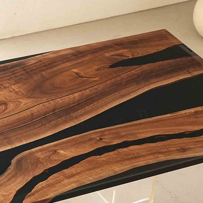 Wooden table with black resin inlay on a light background
