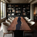 Modern interior with a long wooden dining table and chairs in a room with bookshelves.