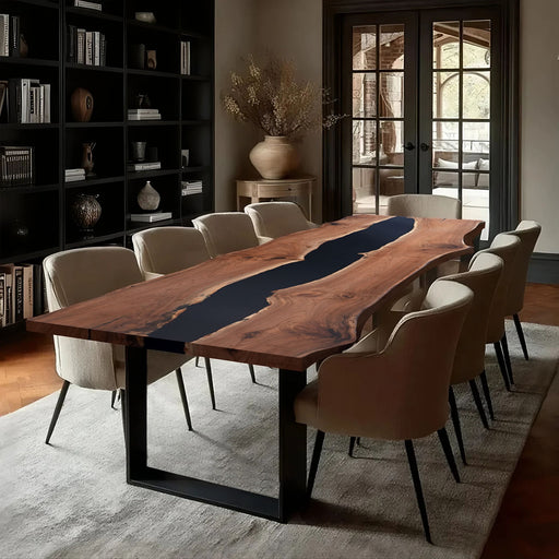 Wooden dining table with black river design in a room with bookshelves and chairs.