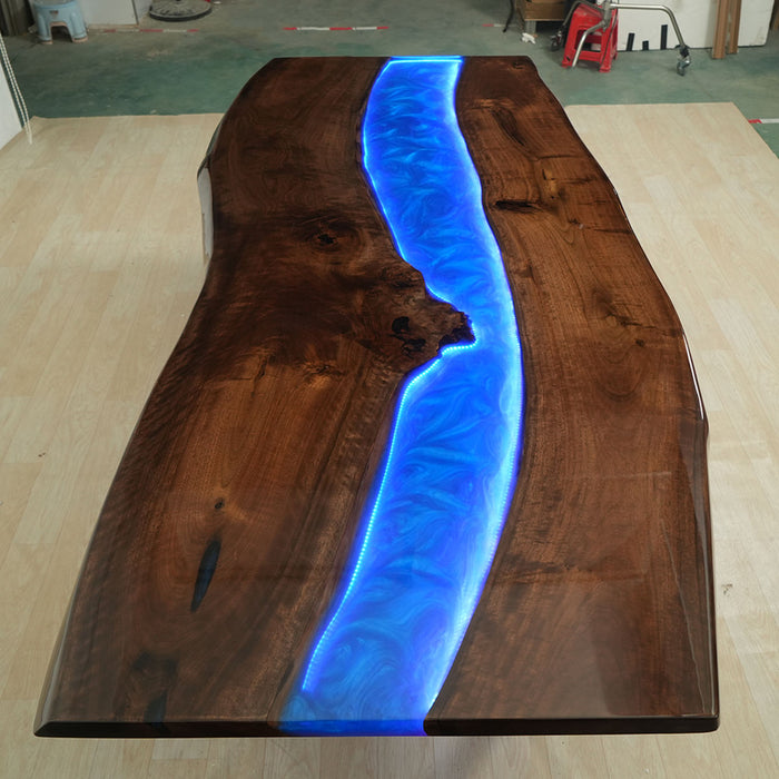 Live edge walnut table featuring a bright blue LED resin channel.