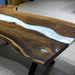 Wooden table with a white resin inlay on a tiled floor.