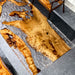 Wooden dining table with a natural, rustic finish on a gray floor.