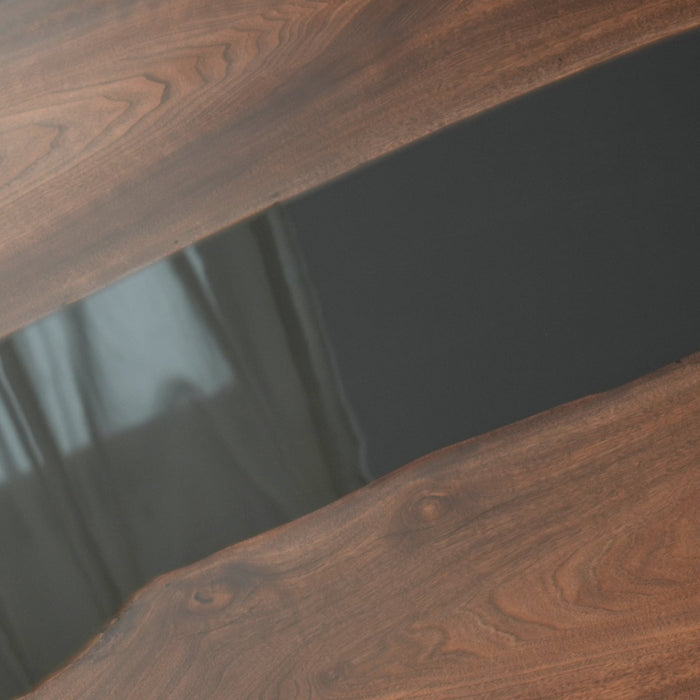 A handcrafted modern epoxy resin wood table with a dark wood grain and a flowing black epoxy resin river 